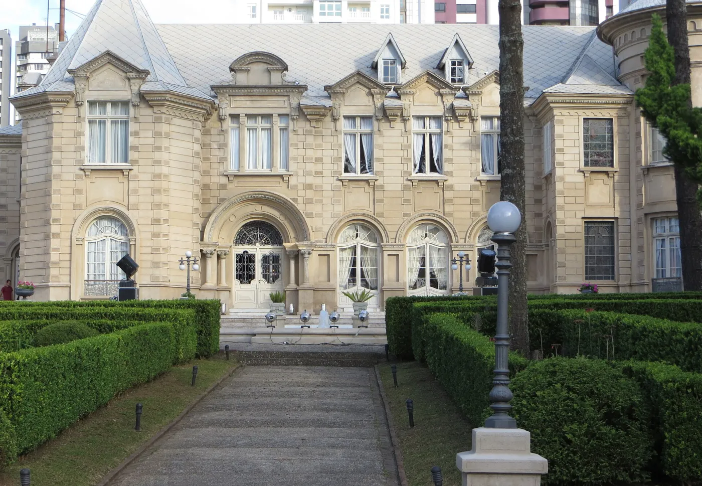 Fachada do Castelo do Batel com portais em arco, janelas altas e poste de luz no jardim
