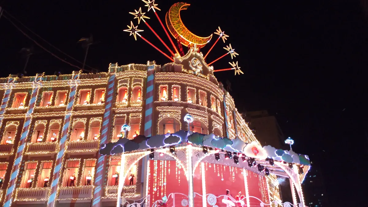 Rua do centro de Curitiba iluminada por luzes de Natal à noite